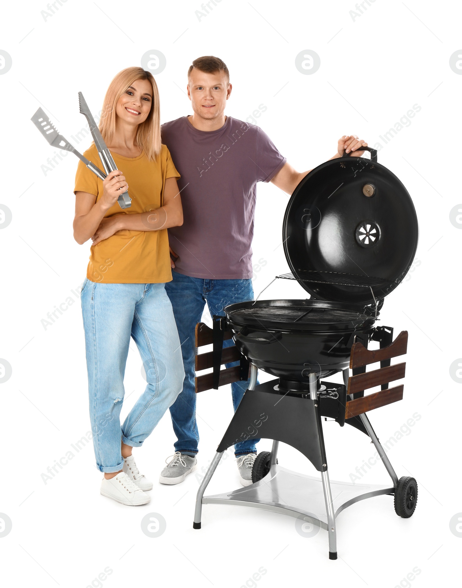 Photo of Happy couple with barbecue grill and utensils on white background