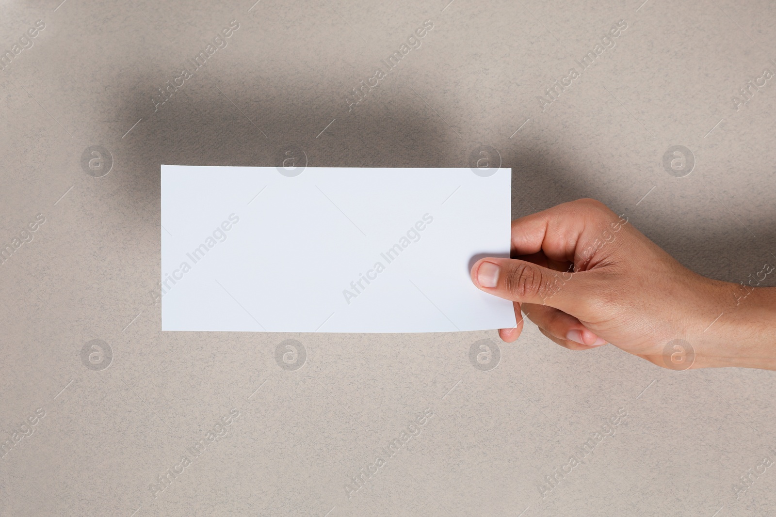 Photo of Man holding flyer on grey background, closeup. Mockup for design