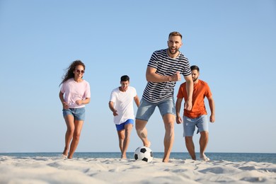 Photo of Group of friends playing football on beach