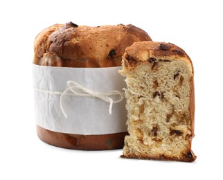 Photo of Delicious Panettone cake with raisins wrapped in parchment paper on white background. Traditional Italian pastry