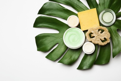 Composition with body care products, wisp and green leaf on white background, top view. Space for text