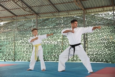 Photo of Boy and coach practicing karate at outdoor gym