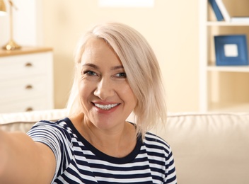 Photo of Mature woman using video chat at home, view from web camera