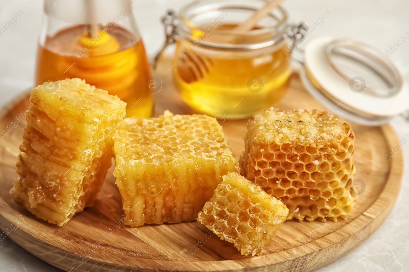 Photo of Fresh delicious honeycombs on wooden board, closeup