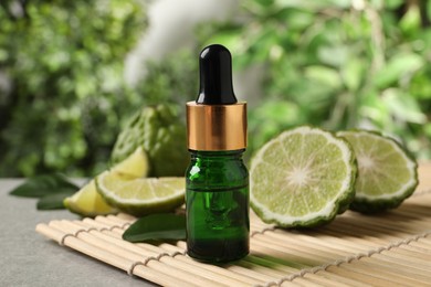 Photo of Glass bottle of bergamot essential oil on table