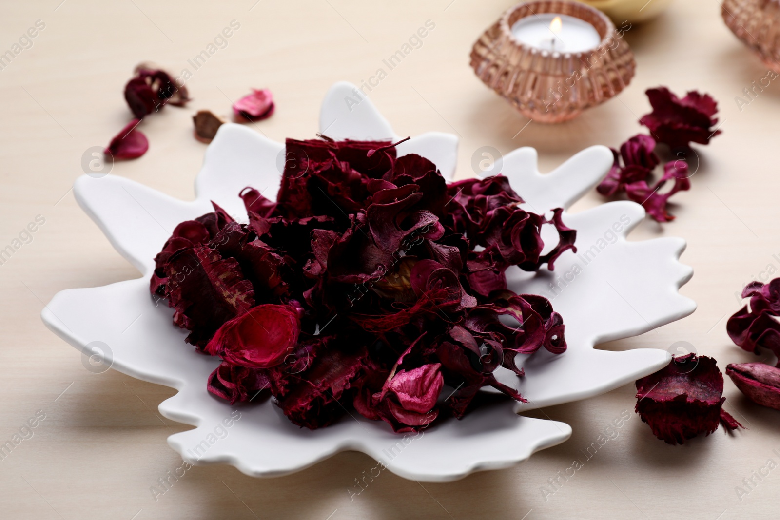 Photo of Aromatic potpourri of dried flowers in plate on table