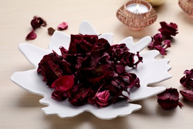 Aromatic potpourri of dried flowers in plate on table