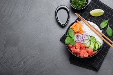 Delicious poke bowl with salmon and vegetables served on grey table, flat lay. Space for text