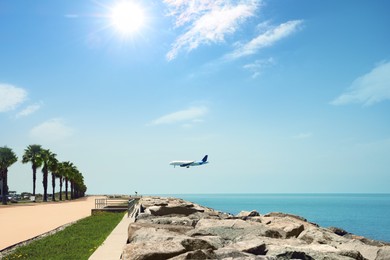 Modern airplane flying in sky over sea