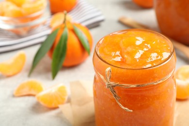 Delicious tangerine jam on table, closeup. Space for text