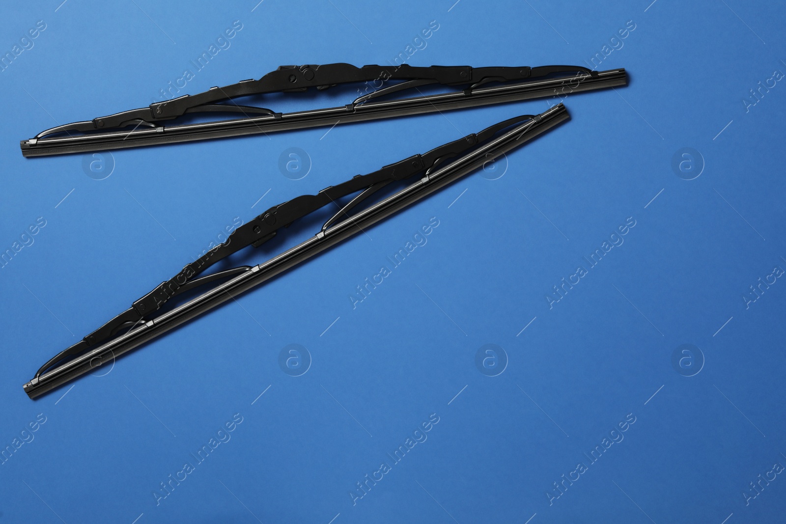 Photo of Car windshield wipers on blue background, flat lay. Space for text