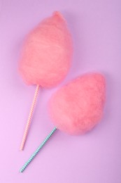 Photo of Two sweet pink cotton candies on lilac background, flat lay