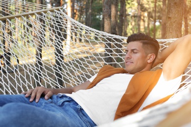 Photo of Handsome man resting in hammock outdoors on summer day