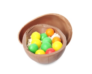 Broken chocolate Easter egg with colorful candies on white background