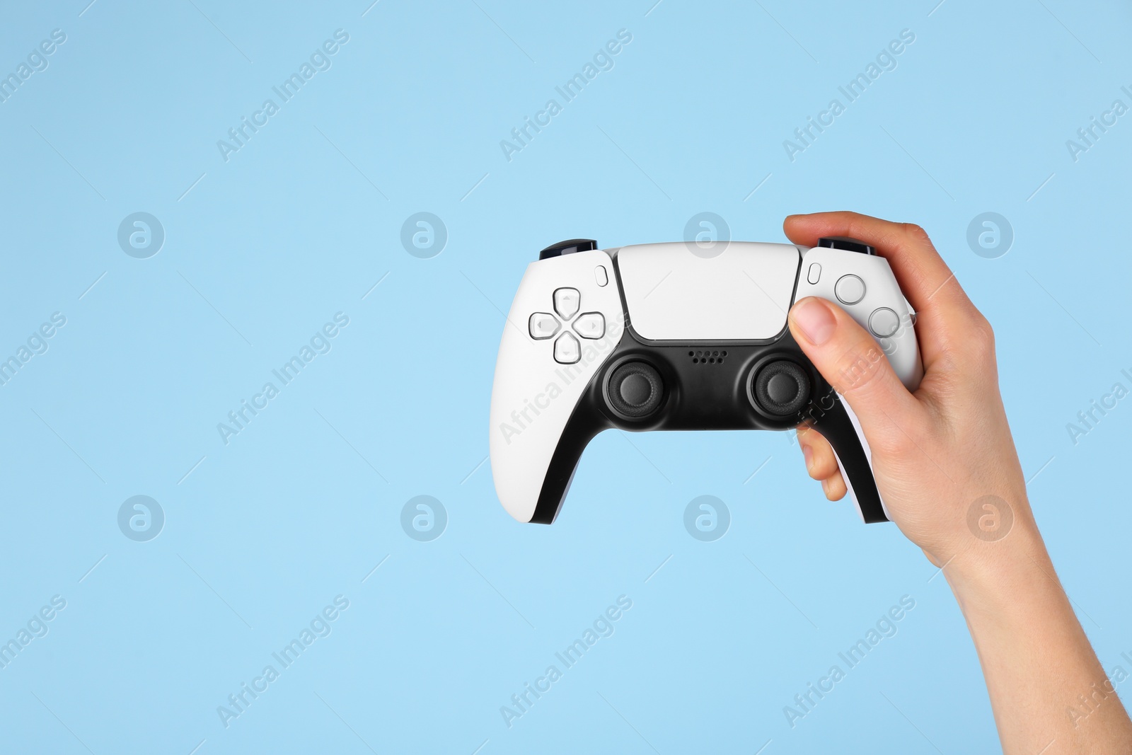 Photo of Woman with game controller on light blue background, closeup. Space for text