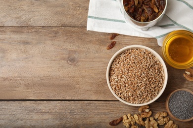 Photo of Ingredients for traditional kutia on wooden table, flat lay. Space for text