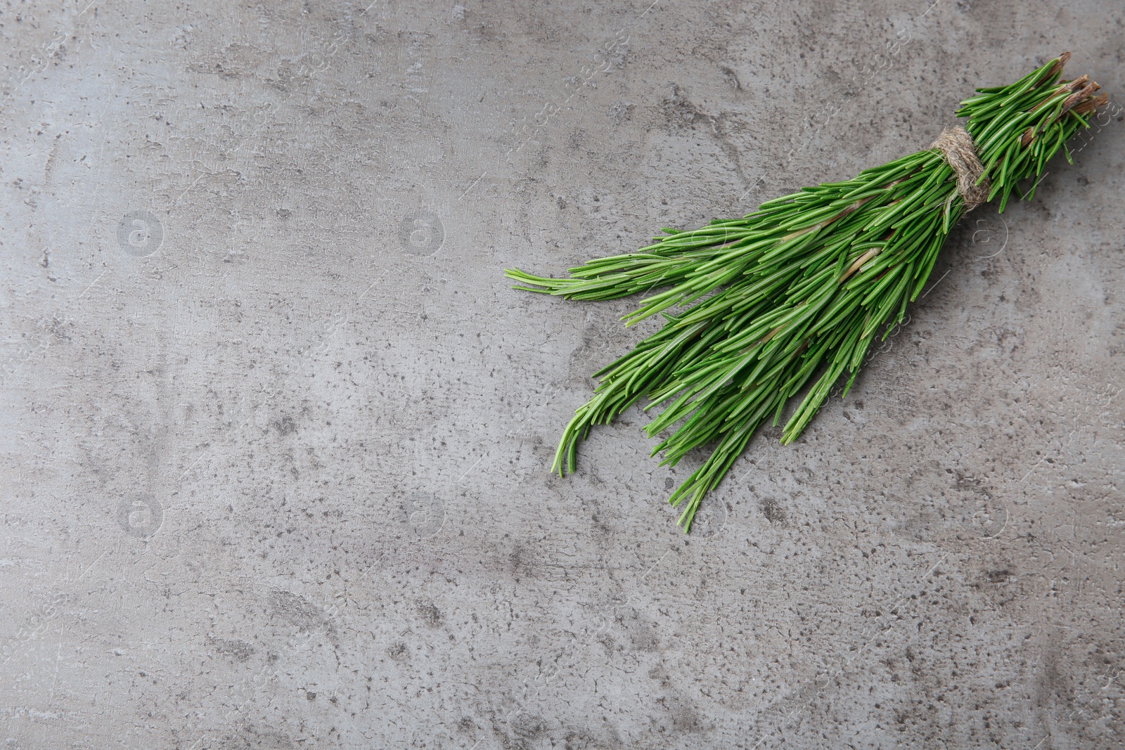 Photo of Bundle of fresh rosemary on grey background, top view. Space for text