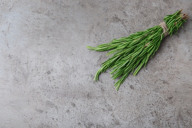 Photo of Bundle of fresh rosemary on grey background, top view. Space for text