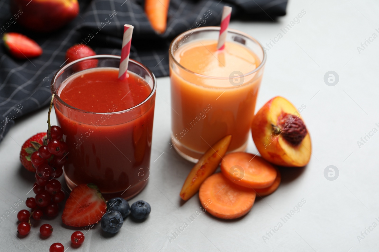 Photo of Delicious juices and fresh ingredients on grey table