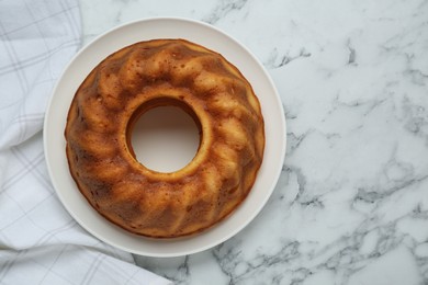 Photo of Homemade yogurt cake on white marble table, top view. Space for text