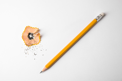 Photo of Graphite pencil and shaving on white background, top view