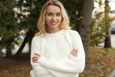 Photo of Happy woman in stylish warm sweater outdoors