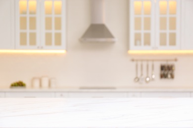 Photo of White marble table and blurred view of modern kitchen interior on background