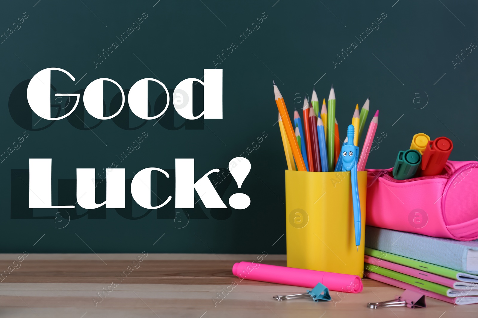 Image of Stationery on wooden table near chalkboard. Good luck