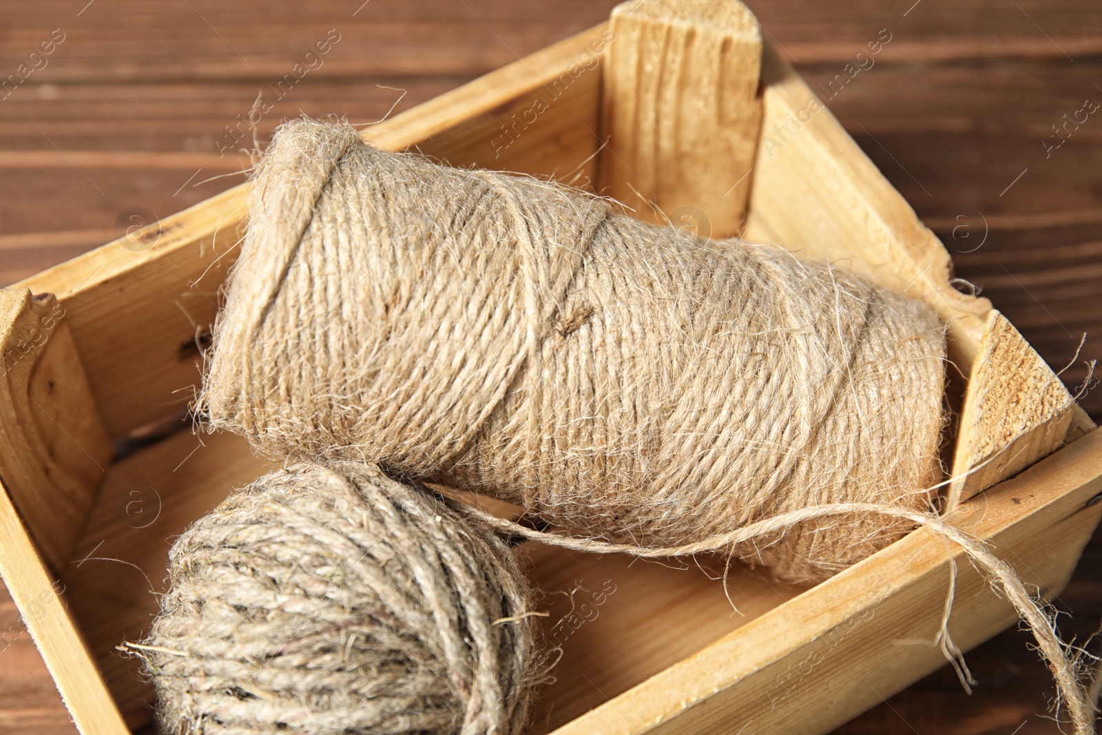 Photo of Wooden crate with hemp ropes on table, closeup