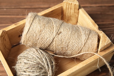 Wooden crate with hemp ropes on table, closeup