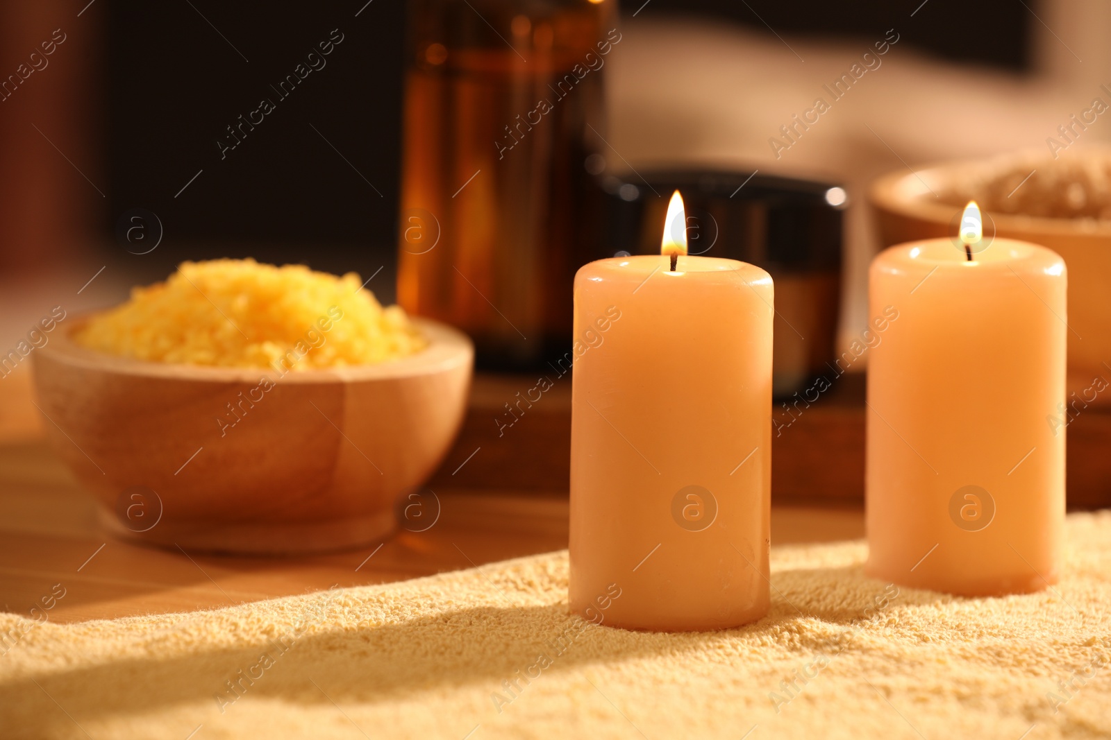 Photo of Spa composition with burning candles and personal care products on soft light surface, closeup