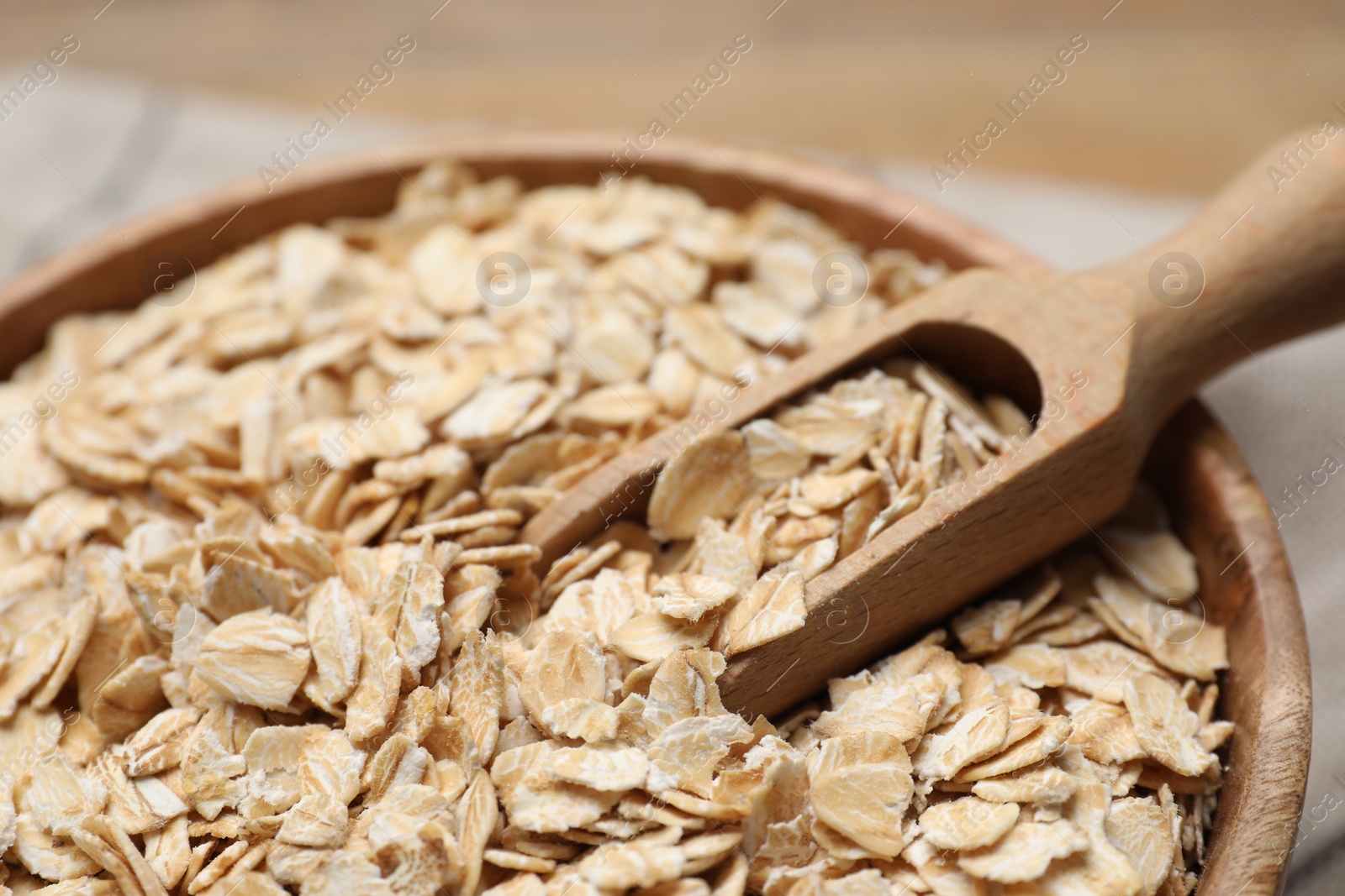 Photo of Bowl and scoop with oatmeal on table, closeup