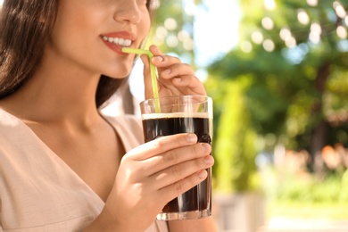 Young woman with cold kvass outdoors, closeup. Traditional Russian summer drink