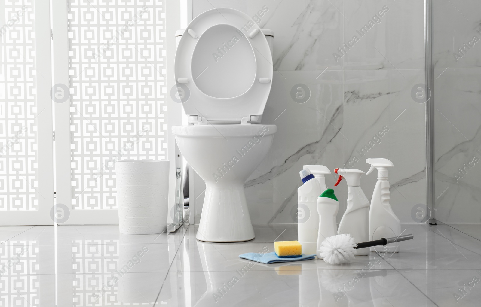 Photo of Toilet bowl and cleaning supplies in modern bathroom