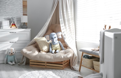 Comfortable armchair in modern baby room interior