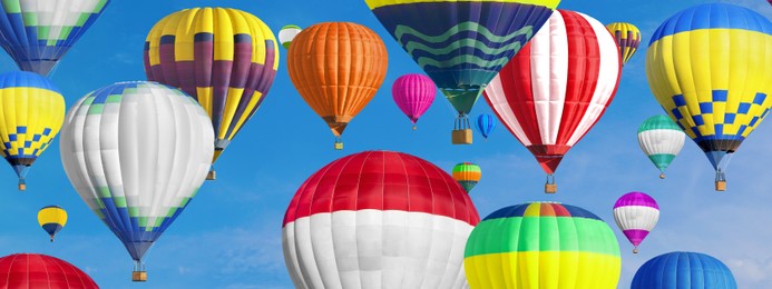 Many bright hot air balloons flying in sky, banner design