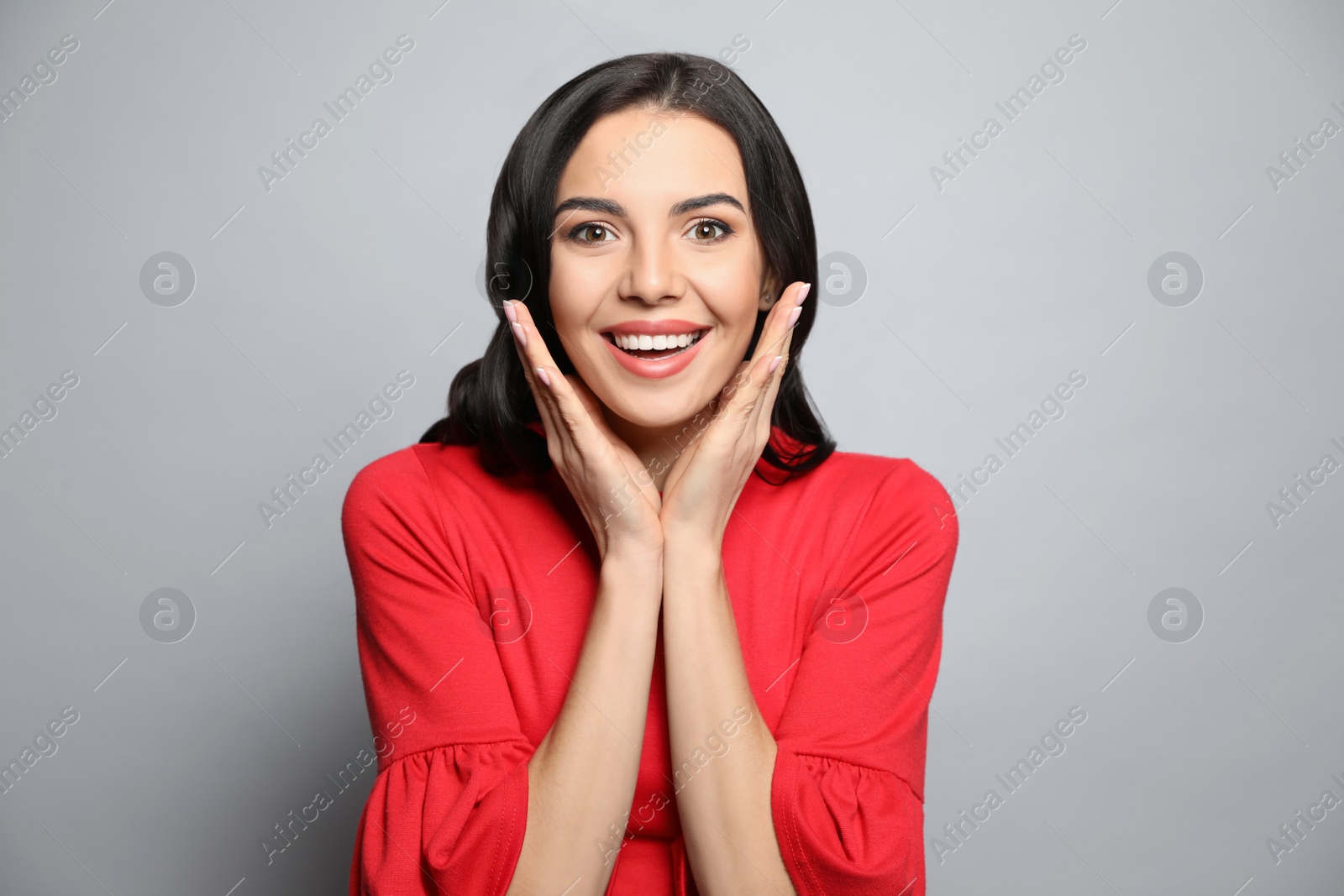 Photo of Portrait of surprised woman on grey background