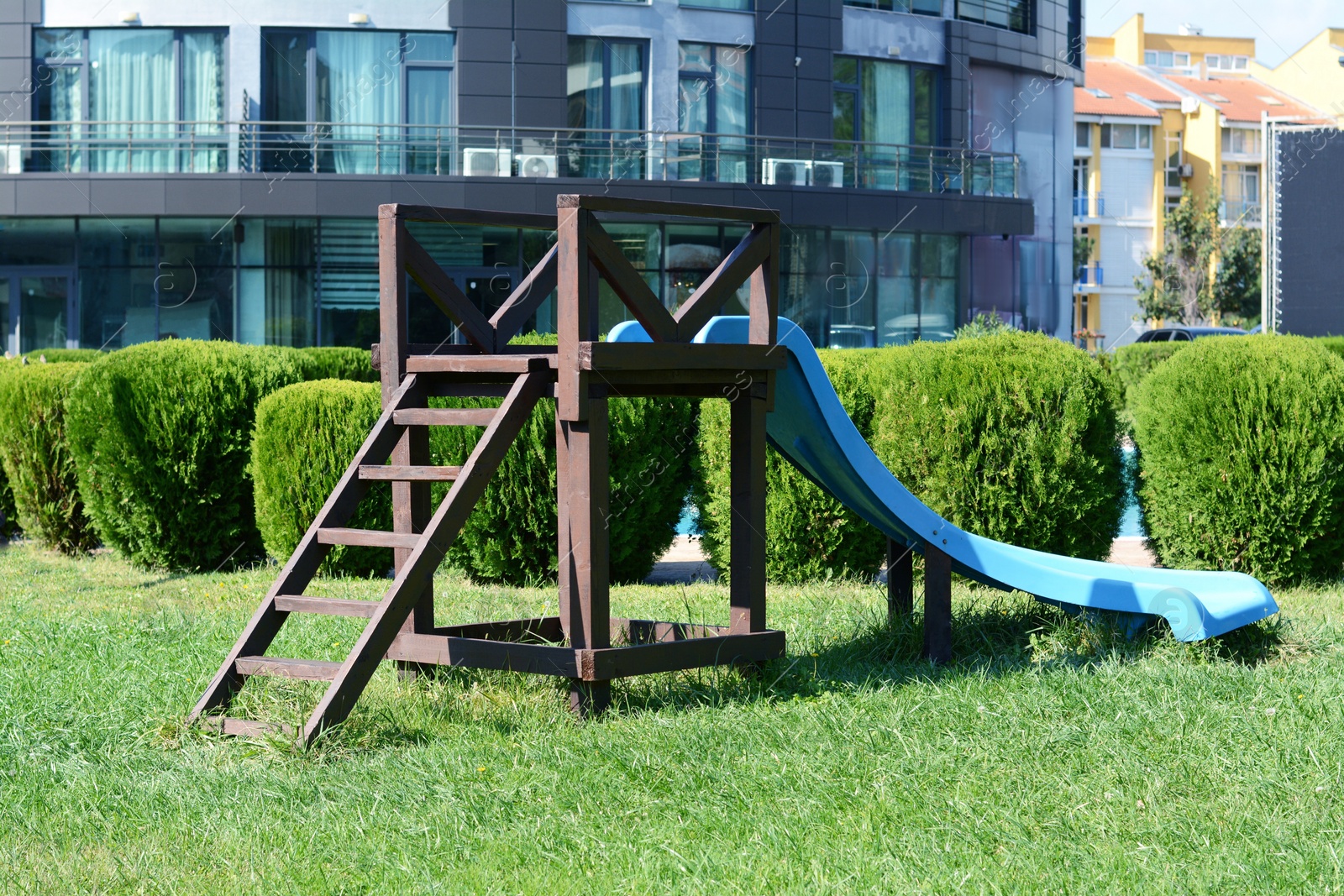 Photo of Children's slide on green grass in park