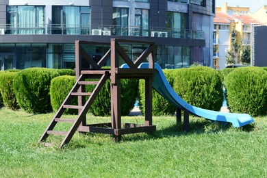 Children's slide on green grass in park