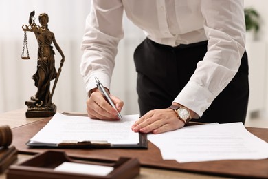 Photo of Lawyer working with documents at table in office, closeup