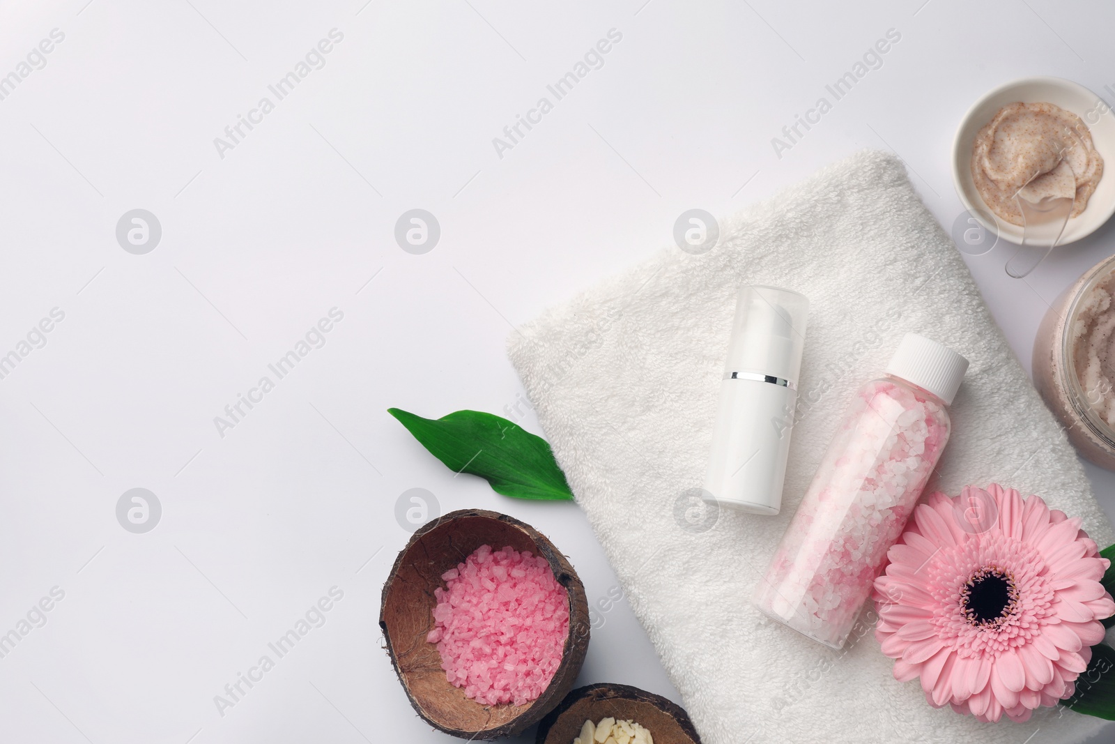 Photo of Flat lay composition with different spa products and beautiful flower on white table. Space for text