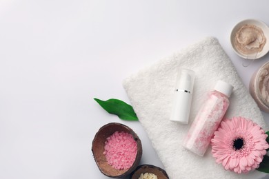 Flat lay composition with different spa products and beautiful flower on white table. Space for text