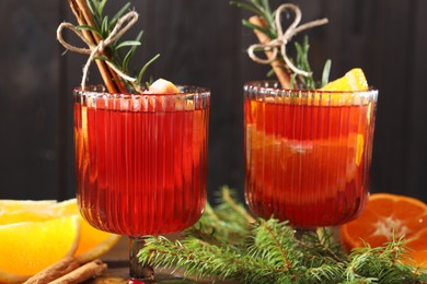 Christmas Sangria cocktail in glasses, ingredients and fir tree branches on table, closeup