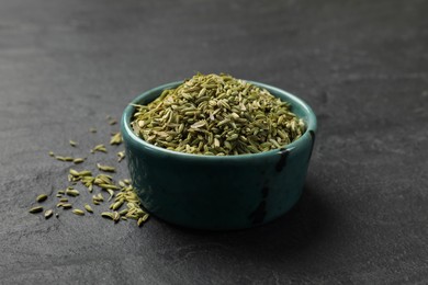 Photo of Fennel seeds in bowl on gray table, closeup