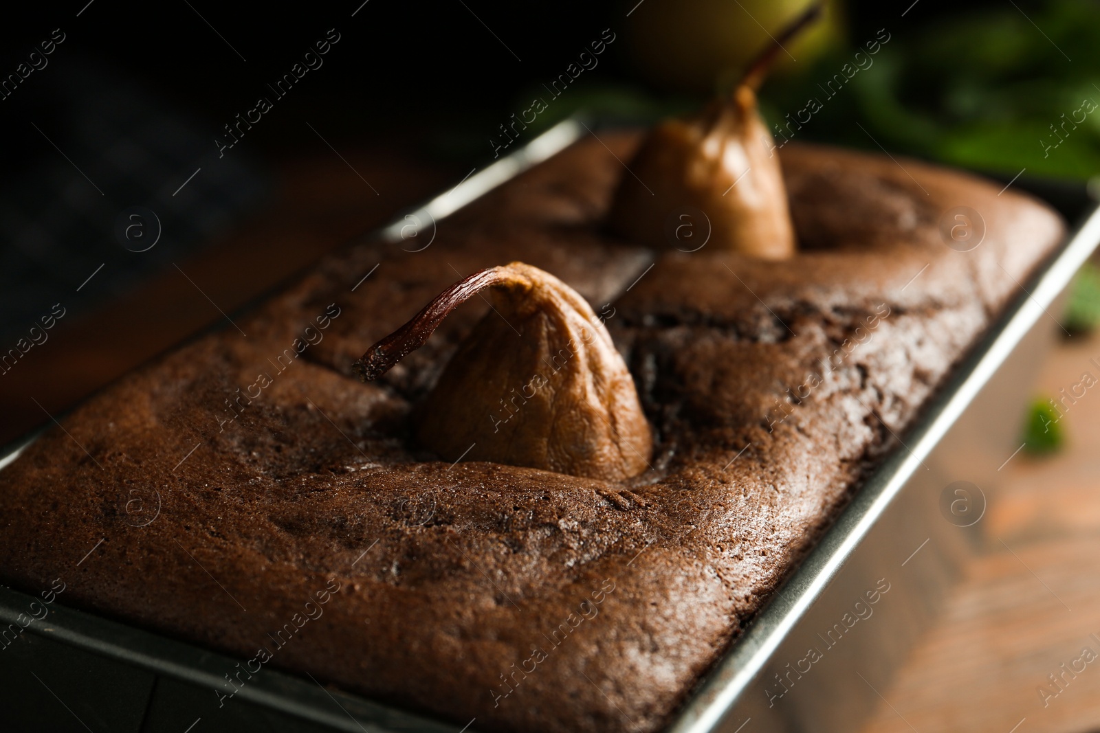 Photo of Tasty pear bread in baking form on table, closeup. Homemade cake