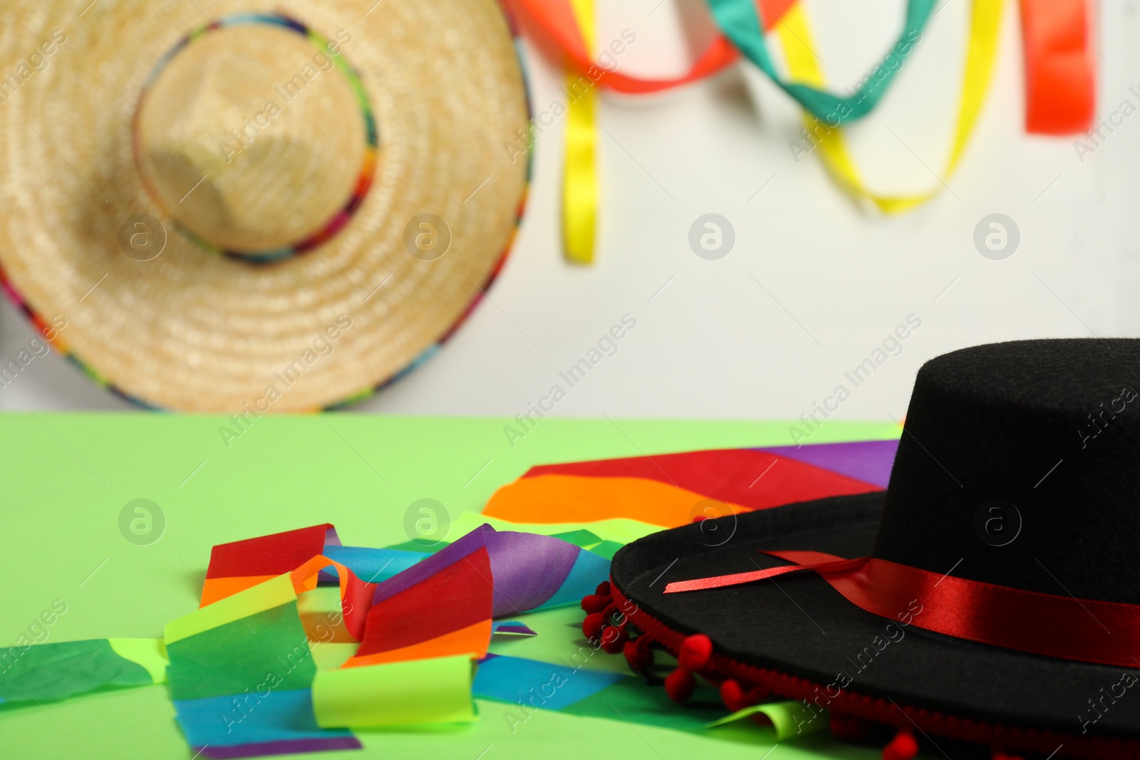 Photo of Black Flamenco hat on green table, closeup. Space for text