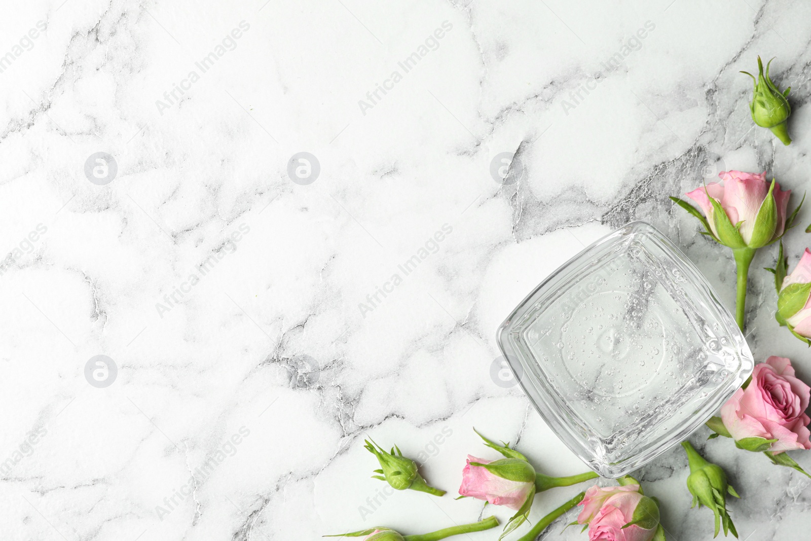 Photo of Flat lay composition with cosmetic gel and beautiful flowers on white marble table. Space for text