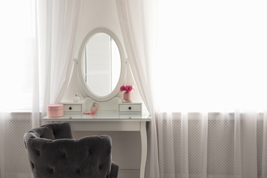 Photo of Elegant white dressing table and armchair in light room