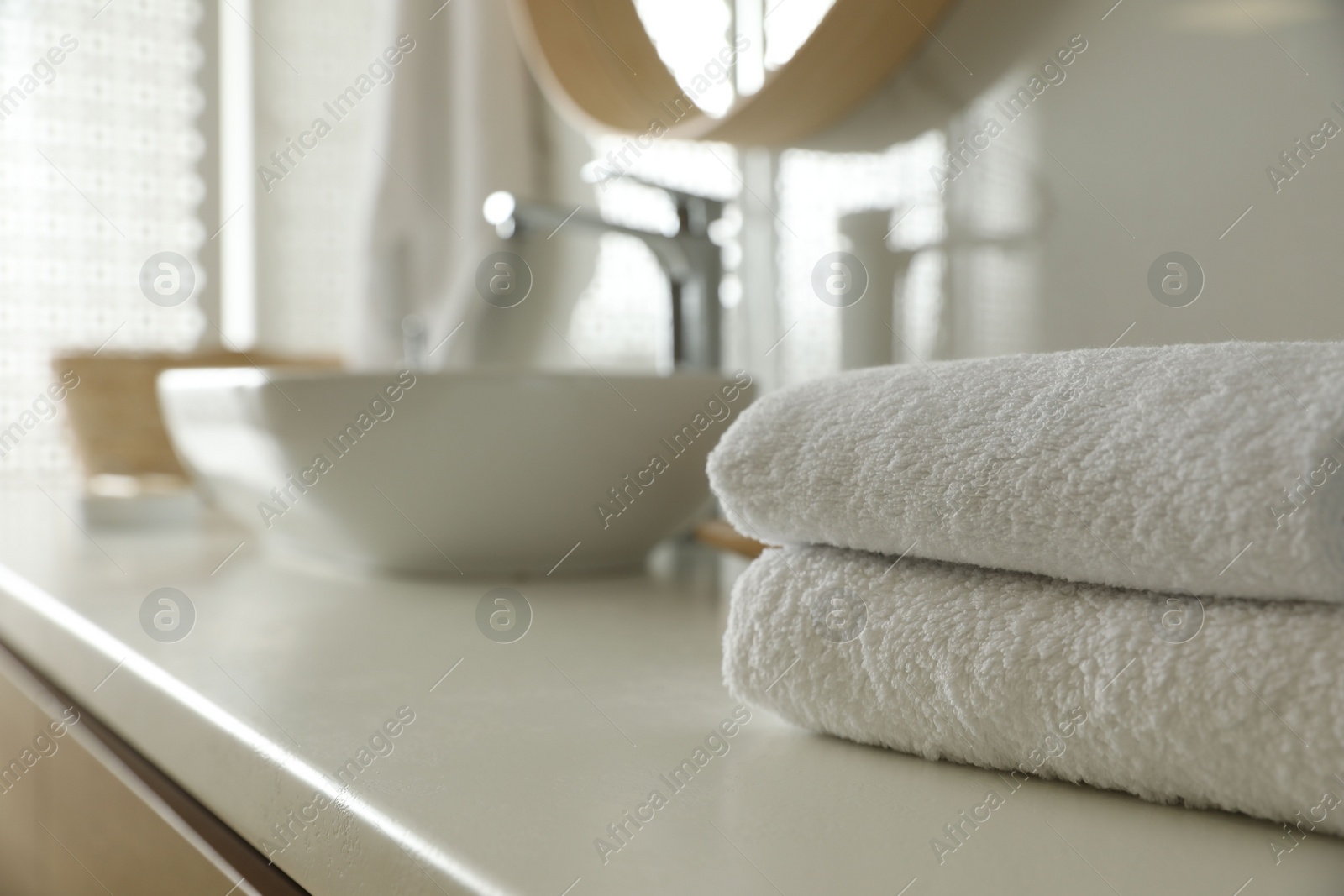 Photo of Stack of clean towels on countertop in bathroom. Space for text