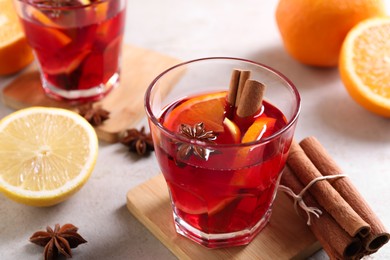 Aromatic punch drink and ingredients on white table, closeup